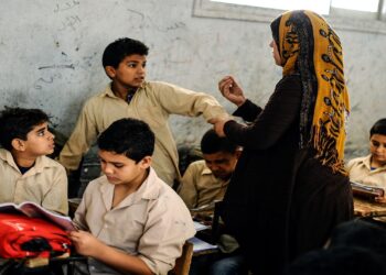 GIZA, EGYPT - OCTOBER 30: An Egyptian student is punished by his teacher during the lesson at a primary school, where nearly 2 thousand students get education, after the Egyptian national anthem performance in Baragil neighborhood of Giza, Egypt on October 30, 2014. Head master of the school complains about the crowded classroom sizes, reaching up to 70, lack of the desks and other impossibilities. Formal education, at every level, is provided freely at state schools in Egypt. Downswing due to the ongoing 4-year unrest, Egypt tries to overcome many difficulties and uncertainties. (Photo by Mohamed Hossam/Anadolu Agency/Getty Images)
