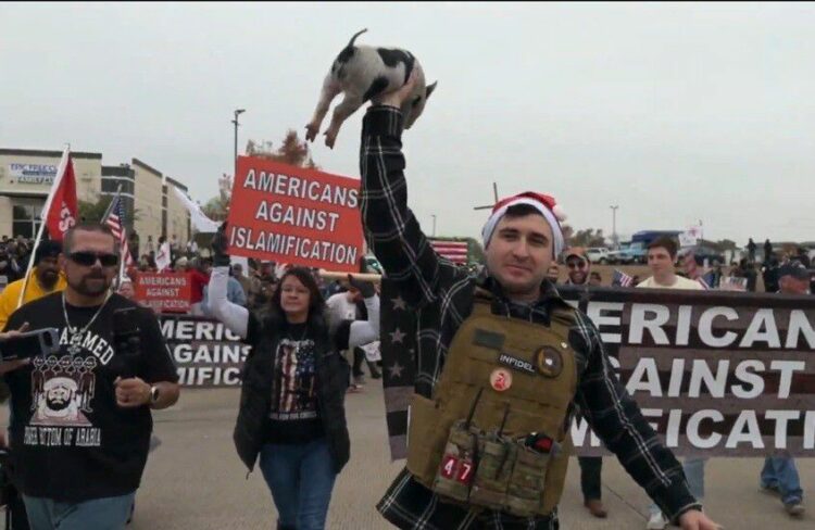 فيديو مثير للجدل : أمريكي يضع نسخة من القرآن الكريم في فم خنزير خلال احتجاج مناهض للإسلام فى تكساس 2025