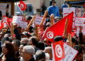 Demonstrators hold placards, Tunisian national flags and baguettes during a protest against Tunisian President Kais Saied's seizure of governing powers, in Tunis, Tunisia March 13, 2022. REUTERS/Zoubeir Souissi