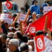 Demonstrators hold placards, Tunisian national flags and baguettes during a protest against Tunisian President Kais Saied's seizure of governing powers, in Tunis, Tunisia March 13, 2022. REUTERS/Zoubeir Souissi